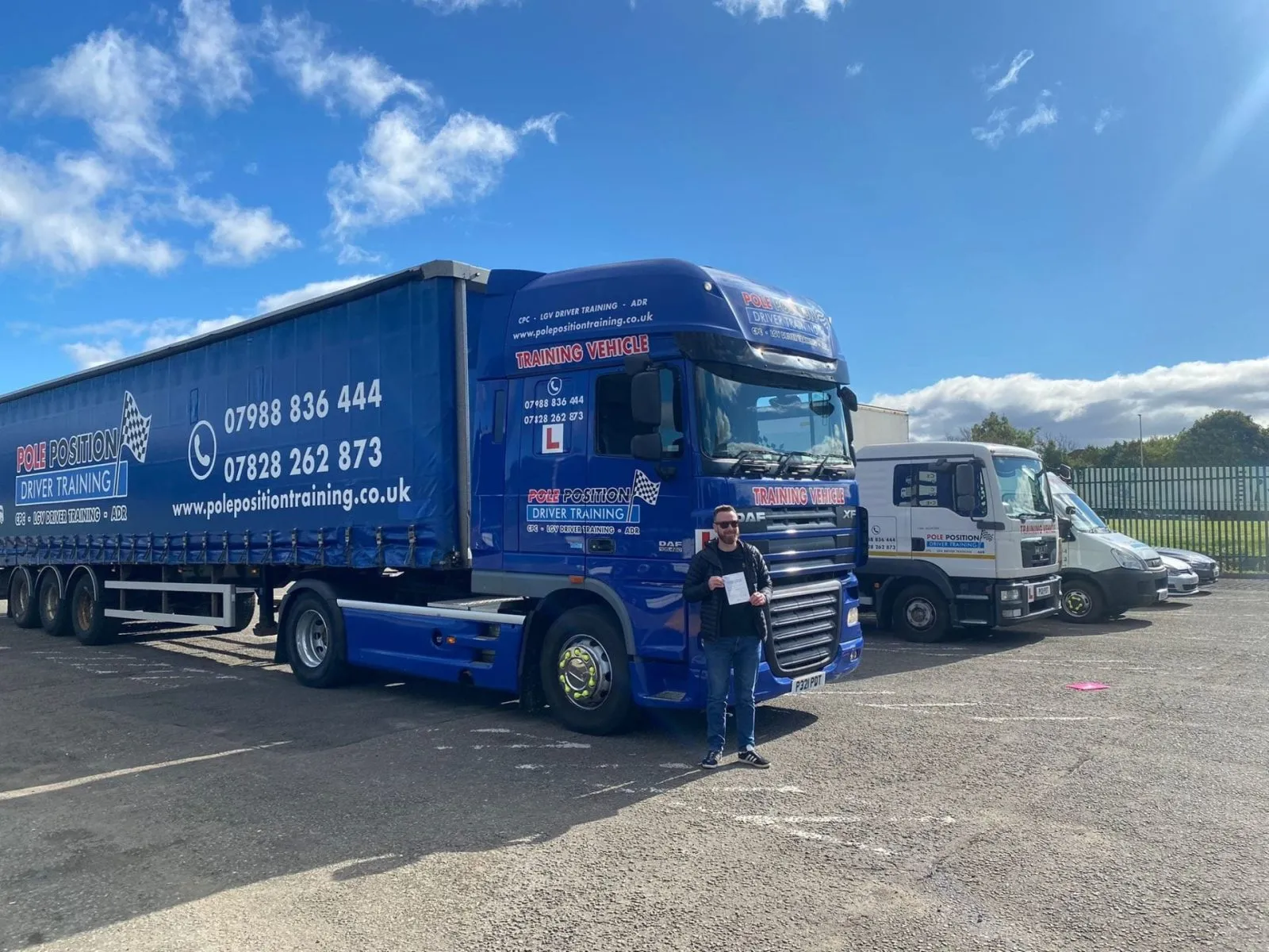Driver beside blue articulated training lorry at Pole Position Driver Training Livingston