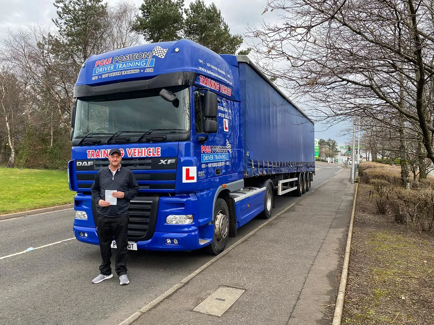 Driver with pass certificate beside articulated lorry Pole Position Driver Training Livingston