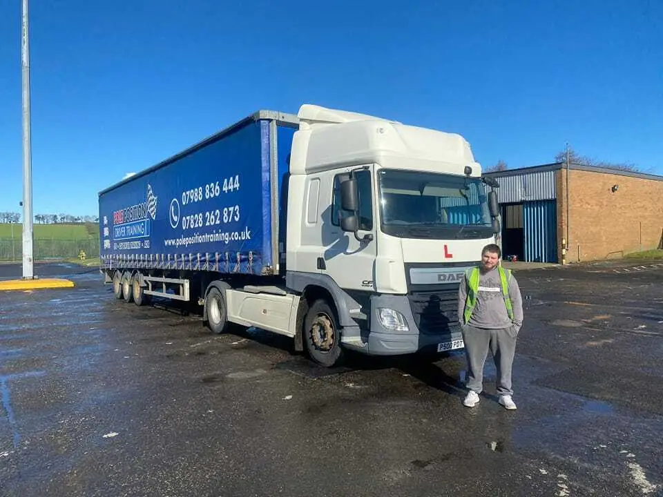 Driver beside an HGV at Pole Position, where driver medicals are arranged in Livingston
